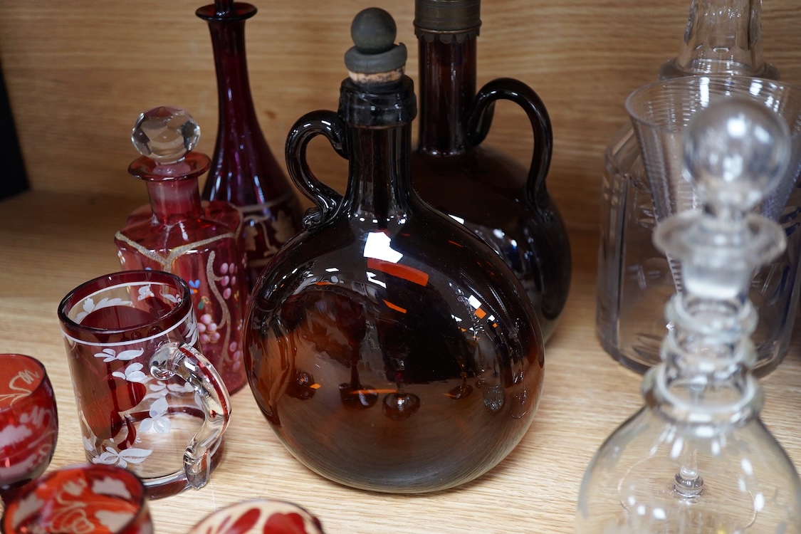 A collection of coloured glass flagons, glasses and bottles etc. (18). Tallest decanter and stopper 25cm high.